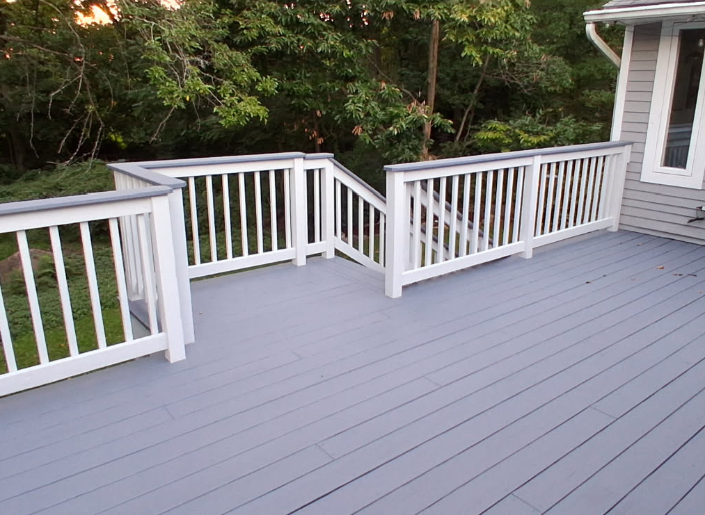 The same deck refinished in smooth grey solid stain with bright white railings